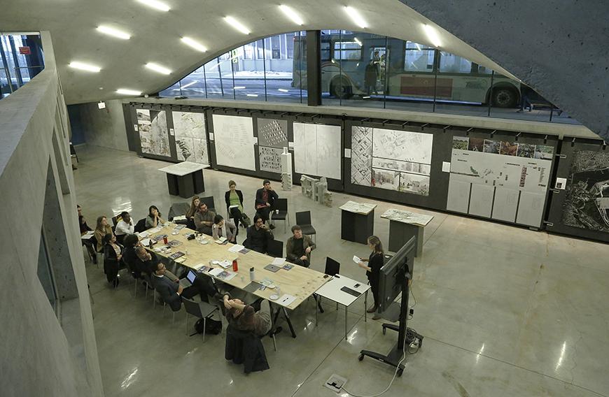 overhead view of a group of students around a table in a concrete dome with overhead lighting