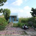 a student sketches outside a small blue house in a tropical environment.