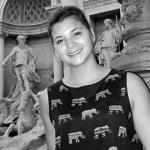 Headshot of a Woman in front of a Statue